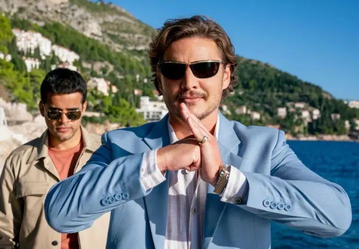 Pedro Pascal w błękitnej marynarce, z dłońmi złożonymi w geście, jakby zapowiadał kolejne z jego filmów i seriali.