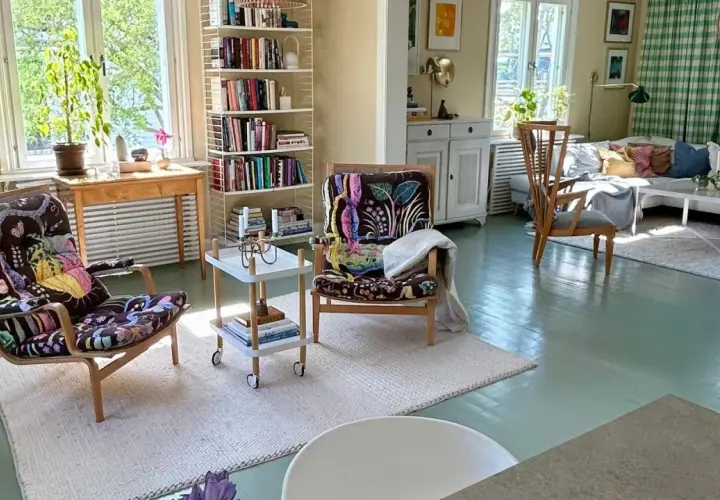Ljust och inbjudande vardagsrum med bokhyllor, färgstarka fåtöljer och en soffgrupp. En harmonisk känsla av feng shui vardagsrum.