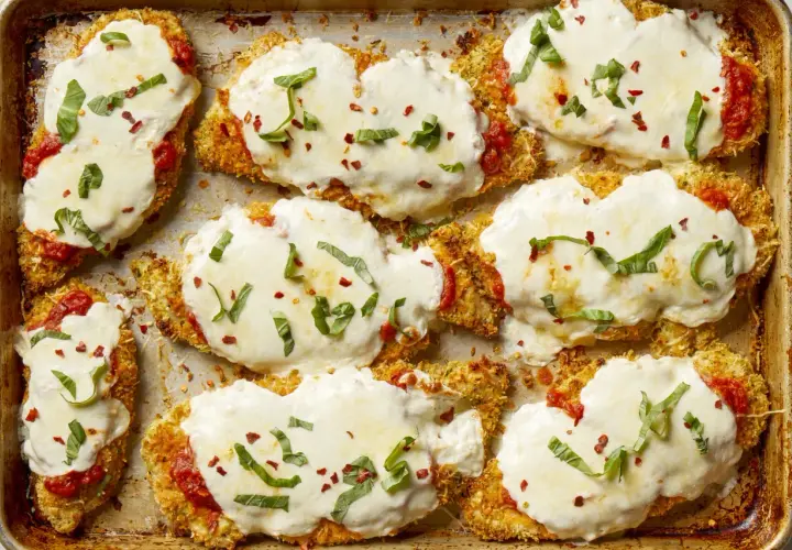 Cotolette di pollo impanate e gratinate con mozzarella filante, salsa di pomodoro e basilico fresco. Un elenco di cibi deliziosi pronti per essere gustati.