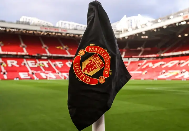 Flaga Manchester United na rogu boiska. Fani spekulują o nowych transferach, a Old Trafford czeka na wzmocnienia.