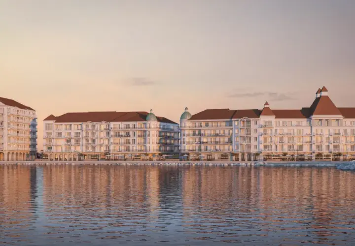 Eleganckie budynki nad wodą, z tarasami i dachami w kolorze cegły. To wizualizacja mariny royale darłowo, idealnego miejsca na wypoczynek.