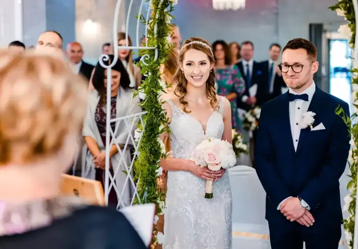 Para wzięła ślub cywilny po rozwodzie. Panna młoda w białej sukni z bukietem, pan młody w granatowym garniturze.