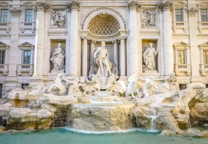 Fontana di Trevi: maestosa opera barocca con Nettuno al centro, cavalli marini e cascate d'acqua. Una descrizione iconica di Roma.