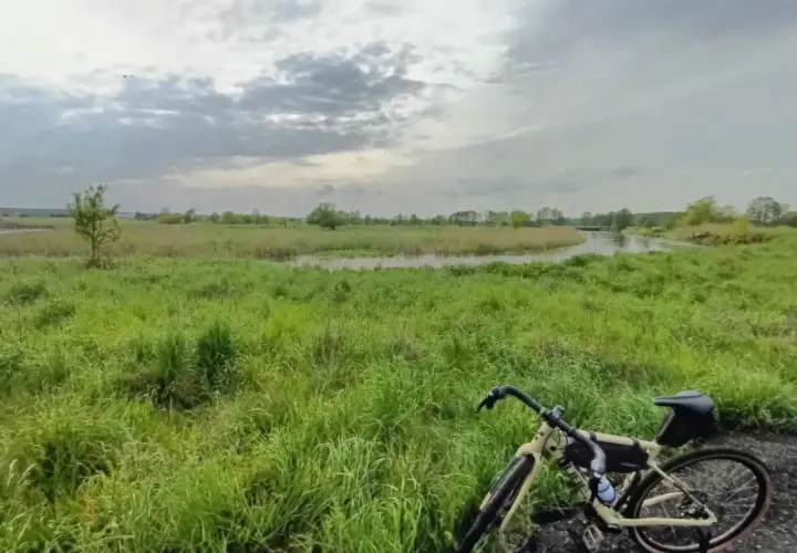 Rower na tle łąk i rzeki, gdzieś w okolicy najwyższego pasma Gór Świętokrzyskich.