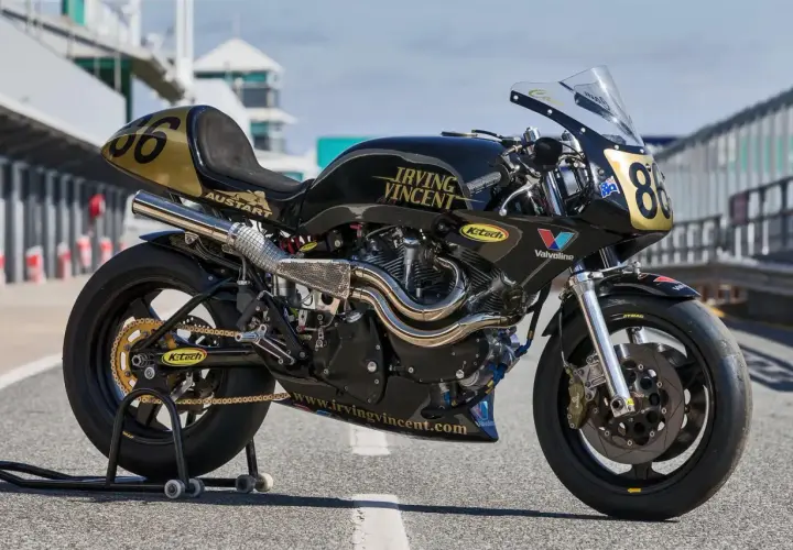 Motocicleta de carreras negra y dorada, modelo Irving Vincent, lista para la pista.