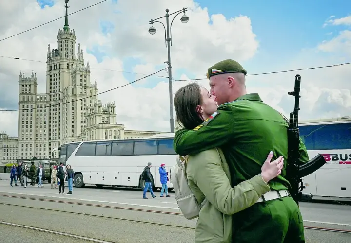 Żołnierz w zielonym mundurze, z karabinem na ramieniu, całuje ukochaną na tle moskiewskiego drapacza chmur. To nie jest sposób, jak podrywa ukrainiec, ale piękny moment pożegnania.