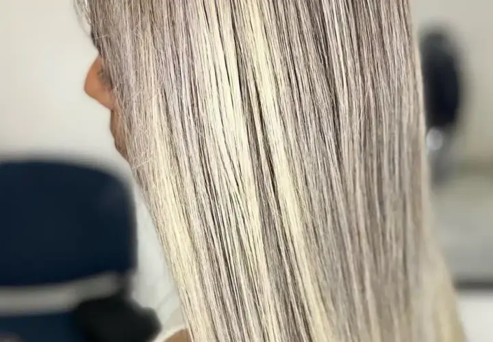 Cabello largo y liso con mechas rubias cenizas, luciendo un estilo moderno y elegante.