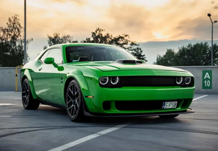 Zielony Dodge Challenger na parkingu. Sprawdź aktualną dodge challenger cena i poczuj moc tego muscle cara.