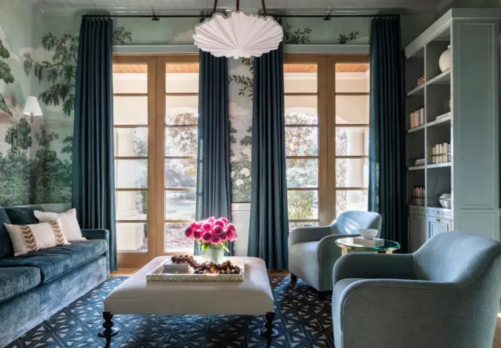 Elegant teal curtains frame French doors, showcasing a lush garden mural and reflecting current curtain trends.