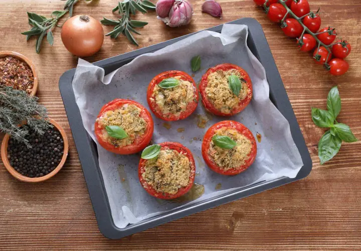 Pomodori ripieni in friggitrice ad aria, dorati e profumati, pronti per essere gustati.