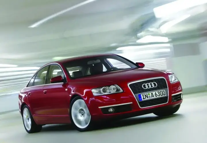 Czerwone Audi A6 C6 2.7 TDI w ruchu, z rozmytym tłem sugerującym prędkość.