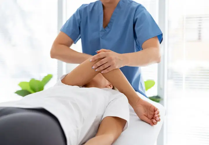 Profesional realiza masoterapia que es una terapia manual para aliviar tensiones y mejorar la circulación.