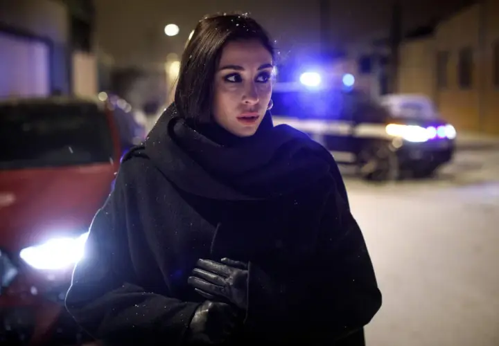 Jana Berzelius står i snö med en polisbil i bakgrunden.