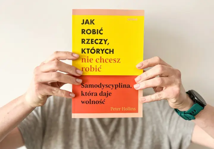 Dwie ręce trzymają książkę "Jak robić rzeczy, których nie chcesz robić". Na okładce hasło: "Samodyscyplina, która daje wolność".