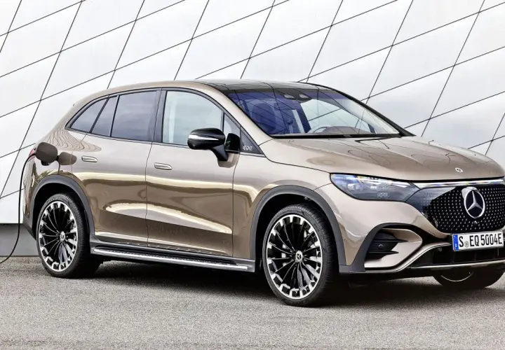 Brązowy Mercedes EQC na ładowaniu przy nowoczesnej ścianie. Stylowy SUV z elektrycznym napędem gotowy do drogi.
