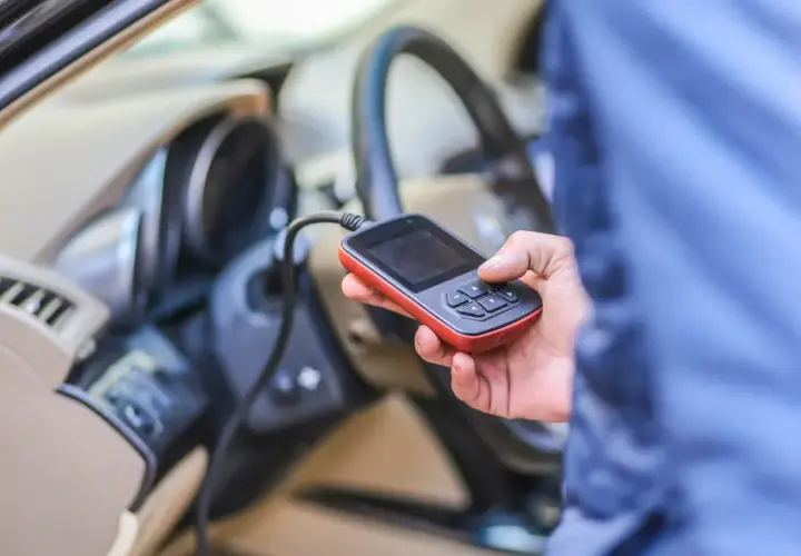 Diagnostyka Renault: ręka trzyma skaner OBD, sprawdzając błędy, np. DTC B1267.
