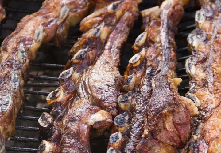 Costillas de churrasco al horno, doradas y jugosas, listas para disfrutar en una parrilla.