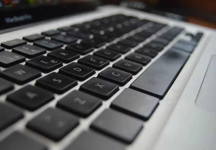 Zbliżenie na klawiaturę laptopa, widoczne klawisze z literami i cyframi. Ustawienie klawiszy jest standardowe, gotowe do pisania.