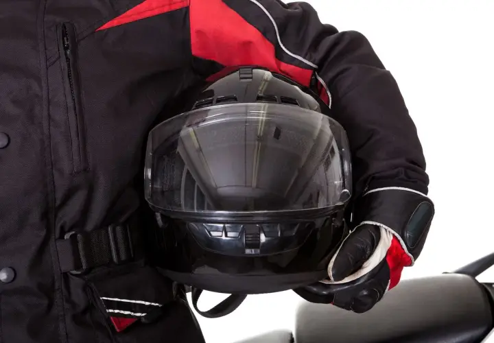 Motociclista con casco negro y chaqueta roja. Aprende como poner pinlock para evitar vaho.