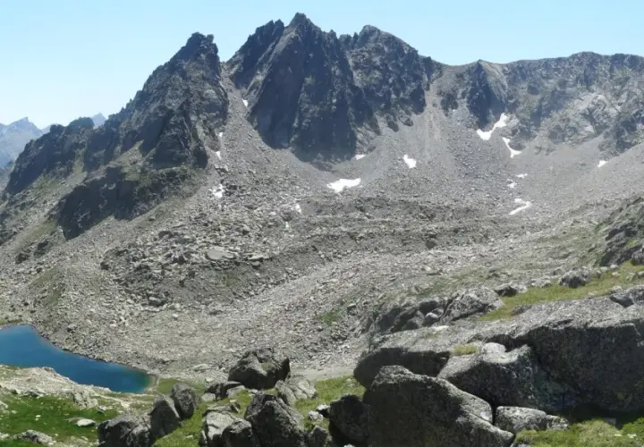 Majestuosas montañas rocosas y un lago azul turquesa en el valle de Aneu.
