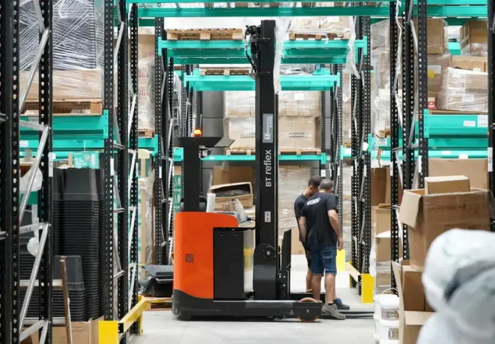 Wózek widłowy w magazynie, pracownicy przygotowują towar do wysyłki. Efektywny outbound logistics.