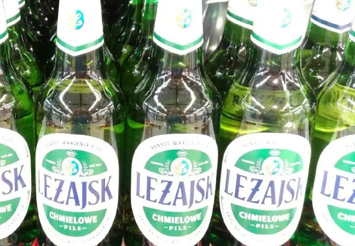 Rząd zielonych butelek piwa Leżajsk Chmielowe Pils. Idealne na letnie wieczory.
