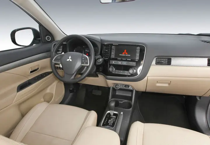 Interior de Mitsubishi Outlander 2.2 Di-D 150. El tablero, asientos y consola central beige sugieren un coche bien cuidado, a pesar de posibles problemas.