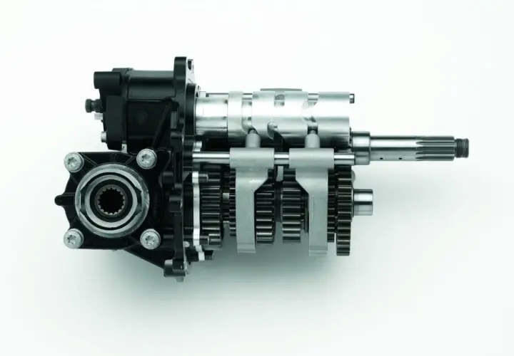 Mechanizm zmiany biegów z widocznymi kołami zębatymi i wałkami, pokazujący, jak działa skrzynia biegów.