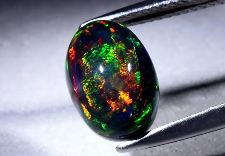 Ein faszinierender schwarzer Opal mit lebendigen Farbspielen von Grün, Rot und Gelb. Seine Wirkung ist magisch.
