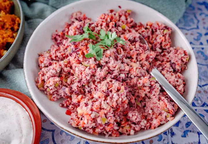 Bunter Karottensalat, frisch zubereitet im Thermomix, garniert mit Petersilie. Daneben eine Schale mit cremiger Sauce.