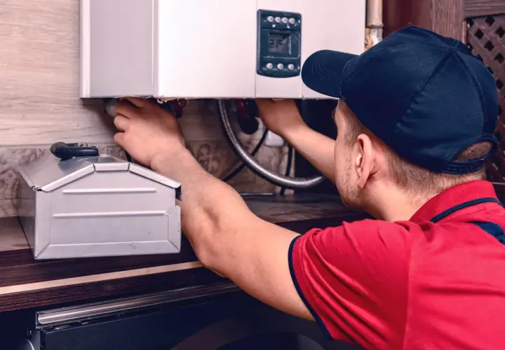 Instalator przy kotle gazowym, który pomoże Ci dowiedzieć się, jak zakręcić wodę w kaloryferze.