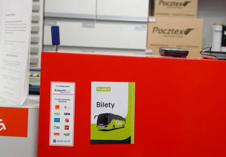 Na czerwonym blacie znajduje się plakat z napisem "Bilety Flixbus". Tutaj możesz kupić bilet na Flixbus.