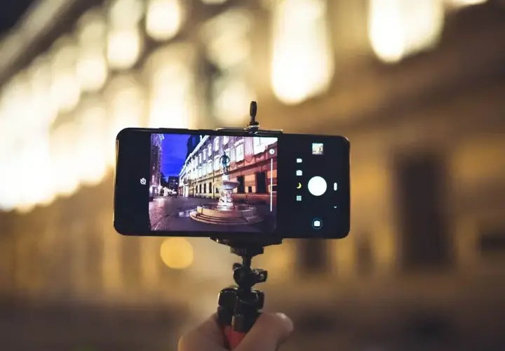 Smartfon na statywie, uchwycił nocną ulicę z fontanną. Dowiedz się, jak ustawić aparat w telefonie, by uzyskać takie ujęcia.
