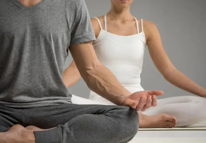 Para ćwiczy jogę kundalini w pozycji medytacyjnej.