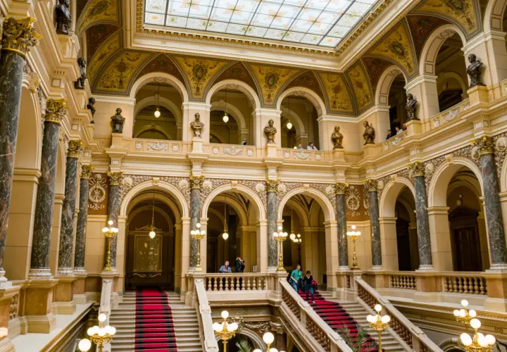 Wnętrze muzeum w Pradze, Czechy. Marmurowe kolumny, złote zdobienia i czerwone dywany na schodach tworzą majestatyczny widok.