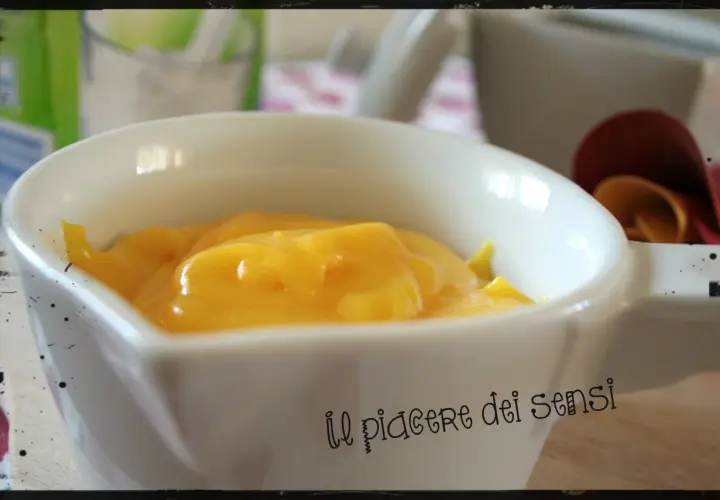 Crema pasticcera ricetta della nonna, densa e vellutata, servita in una ciotola bianca. Un dolce abbraccio di sapori.