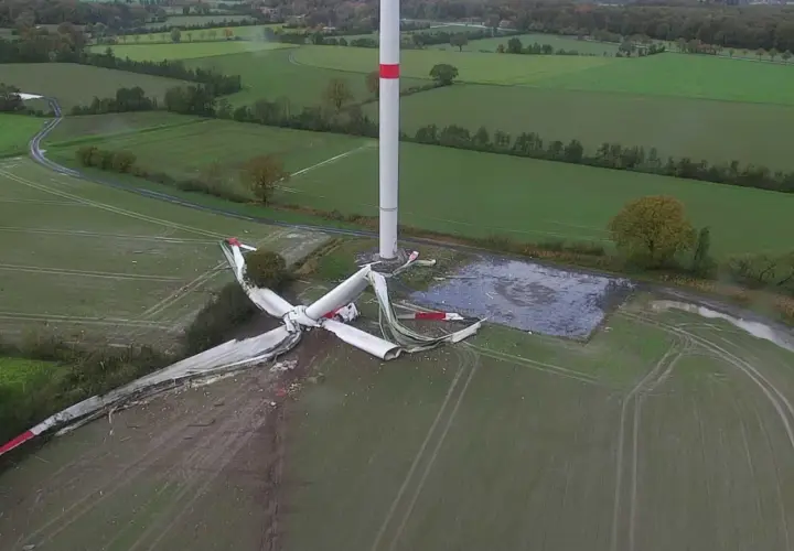 Ein Windrad Unfall hat die Rotorblätter zerfetzt. Trümmer liegen verstreut auf dem Feld neben dem intakten Turm.