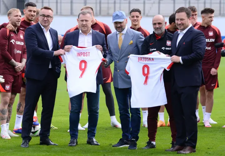 Piłkarze reprezentacji Polski z koszulkami od sponsorów. Wśród nich widać logo InPost i Orlen.
