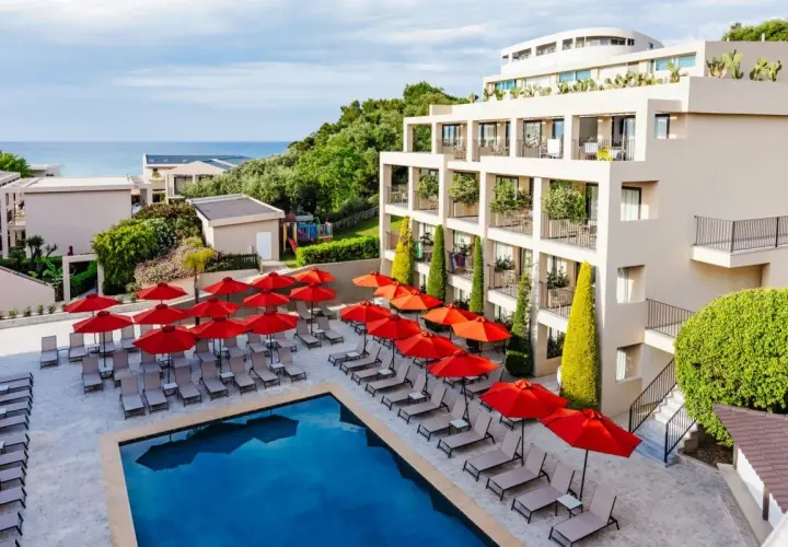 TUI Suneo Tsilivi Admiral: basen z leżakami i parasolami, nowoczesny hotel, morze w tle.