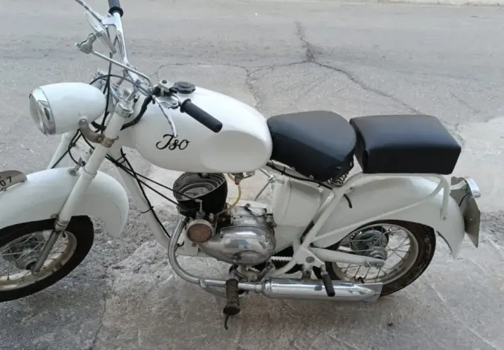 Ciclomotor histórico blanco, modelo Iso, con asiento doble y detalles cromados.