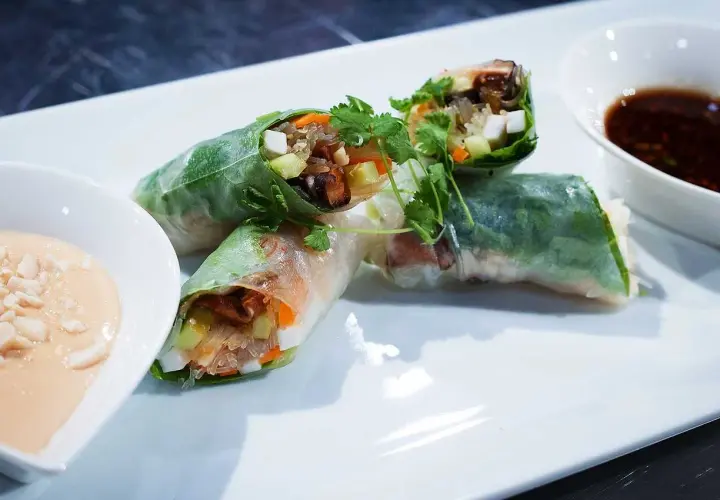 Färska vietnamesiska vårrullar med grönsaker och nudlar, serverade med två dippsåser. Perfekt som förrätt eller lätt måltid.