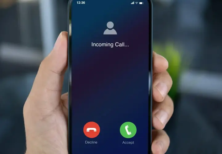 Dłoń trzyma smartfon z ekranem "Incoming Call...". Dowiedz się, jak dzwonić przez internet za darmo, by zawsze być w kontakcie.