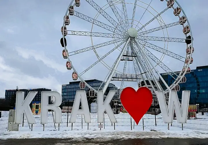 Litery "Kraków" z sercem i diabelski młyn w tle. To jedne z fajnych miejsc w Krakowie, idealne na zimowe zdjęcia.