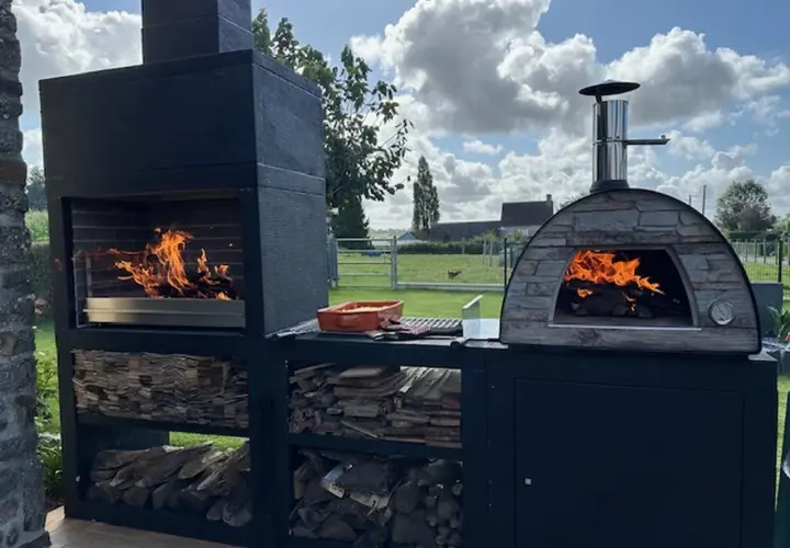 Barbecue et four à pizza en pierre, prêts pour un festin. La grille au fond du barbecue sert à soutenir le bois et à laisser les cendres tomber.