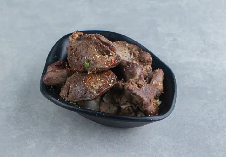 Aksamitna wątróbka z airfryer, doprawiona ziołami, podana w czarnej misce.