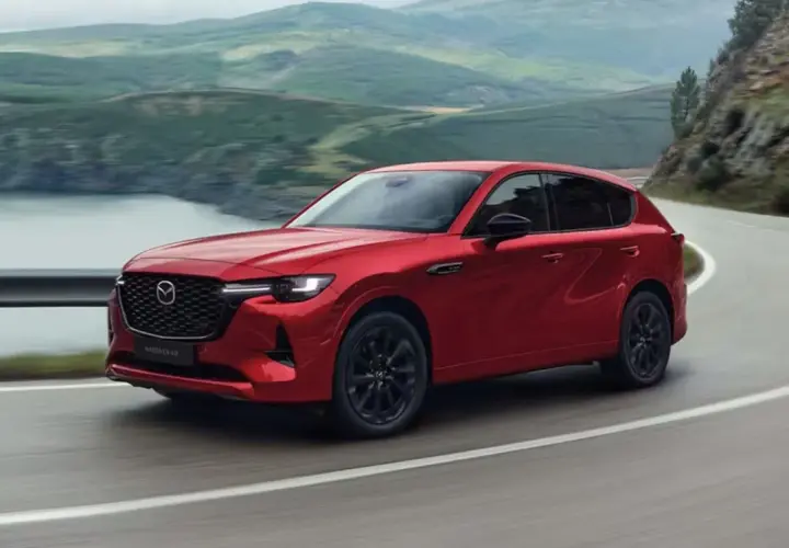 Czerwona Mazda CX-60 3.3 diesel pokonuje zakręt na malowniczej drodze.