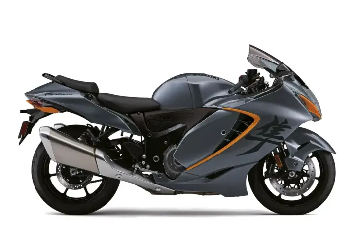 Motocicleta Suzuki Hayabusa gris con detalles naranjas, lista para la velocidad. Su diseño aerodinámico sugiere potencia, como si tuviera un turbo oculto.