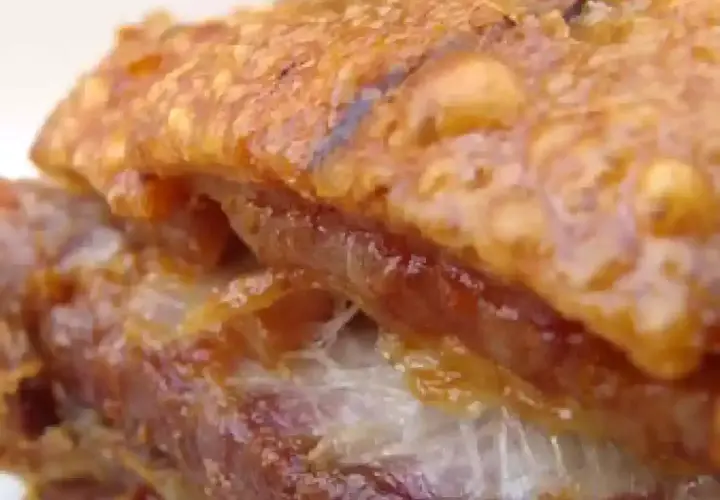 Gros plan sur un délicieux lard rôti au four, la couenne croustillante et dorée, la chair tendre et juteuse. Un vrai régal !