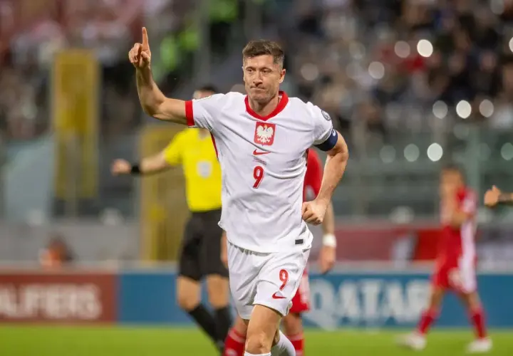 Robert Lewandowski, jeden z najlepszych polskich piłkarzy, świętuje bramkę. Jego biała koszulka z orłem i numerem 9 to symbol dumy narodowej.