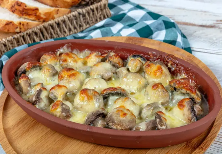 Pyszne pieczarki z piekarnika, zapieczone pod ciągnącym się serem, kuszą aromatem. Idealne na przekąskę lub dodatek do obiadu.